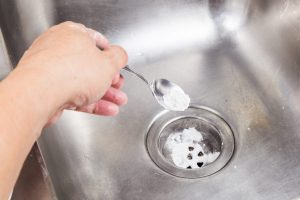 Baking soda poured to unclog drainage system at home.