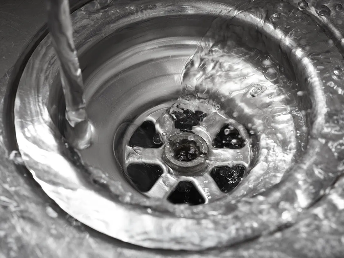 Water running down a stainless steel sink drain
